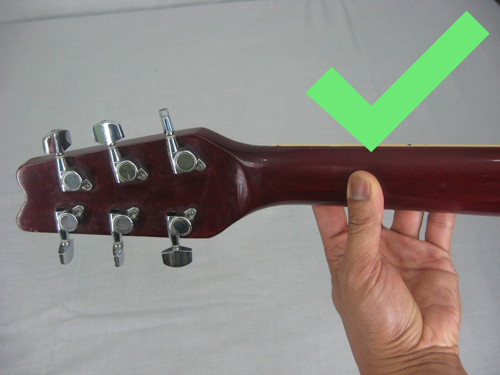 Posição certa do polegar atrás do braço do instrumento
